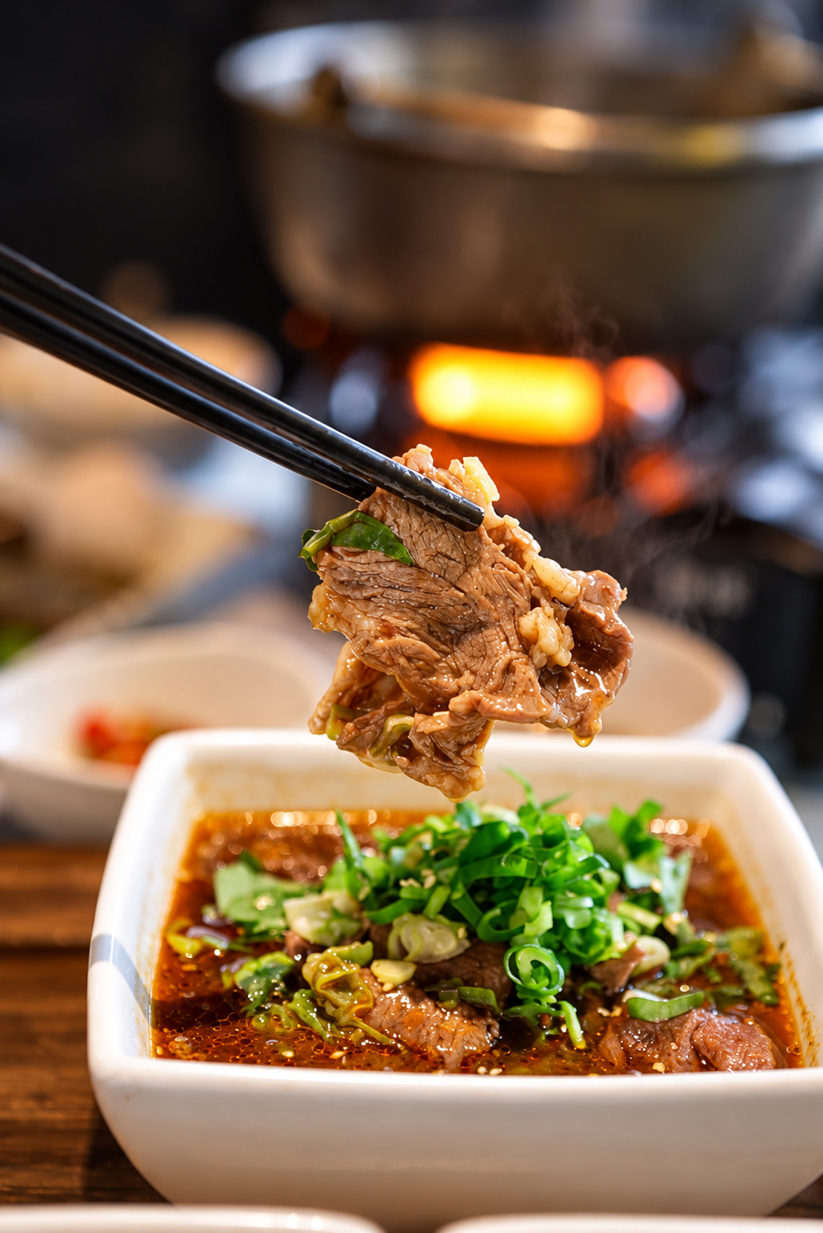 水煮椒香牛肉簡餐，筷子夾起牛肉，碗中搭配椒香湯汁與香菜