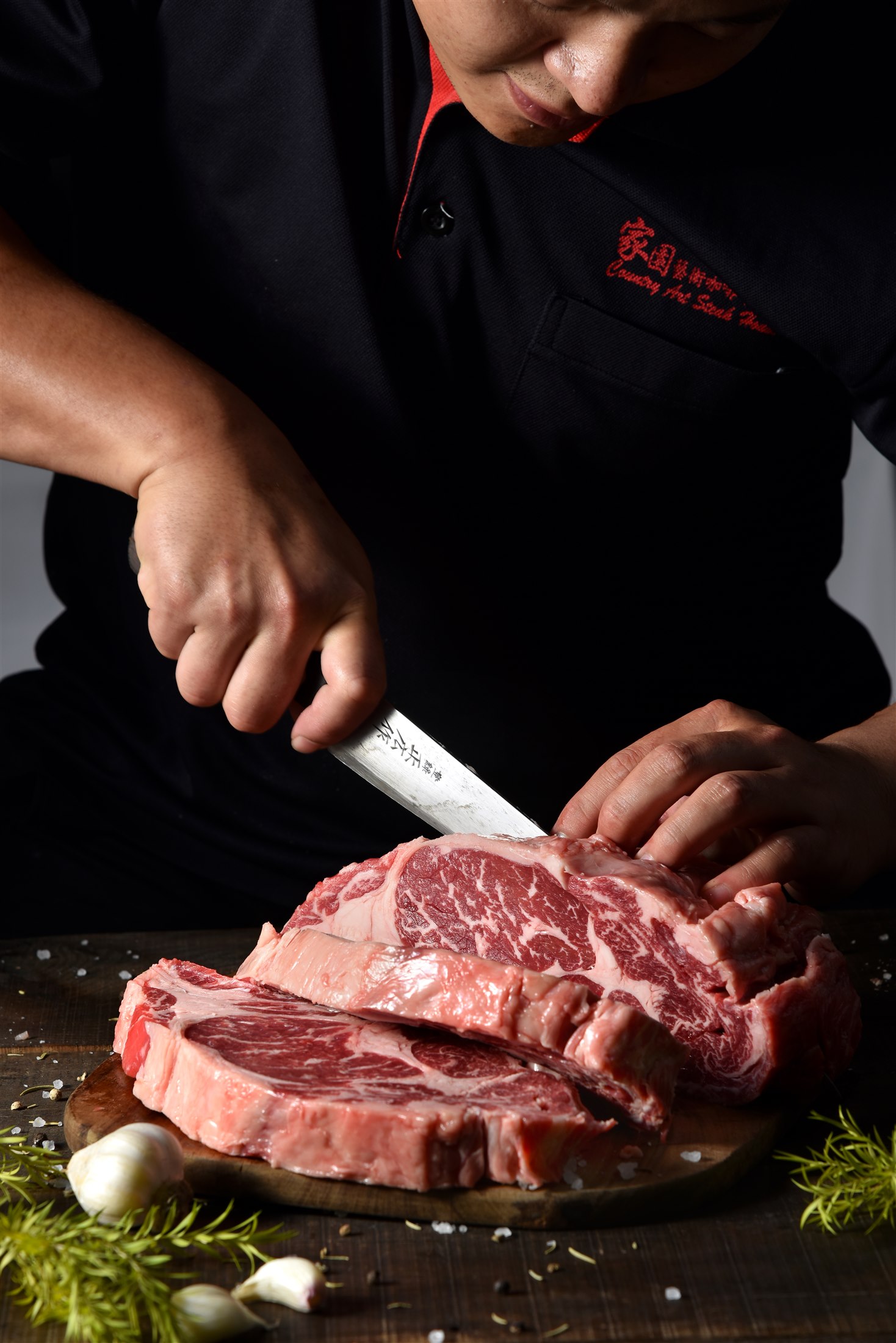 家園師傅穿著店名制服，親手修清與裁切牛肉，手、刀與肉品完整入鏡
