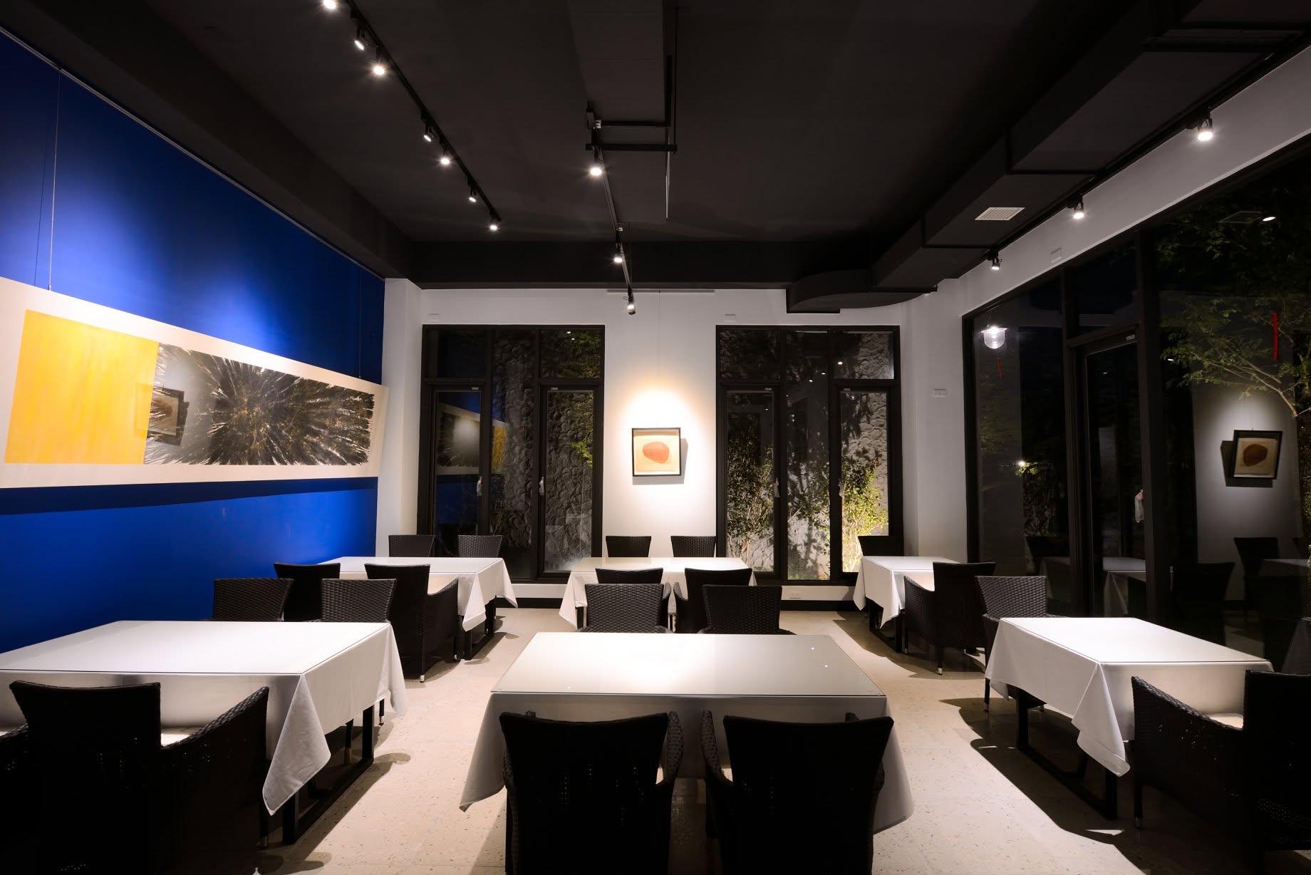 家園室內餐桌,白色桌布、牆面畫作與窗景